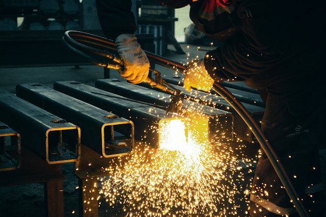 Torch cutting steel square tubing, sparks flying